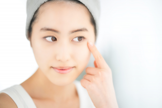 ヘアバンドして目を触る女性