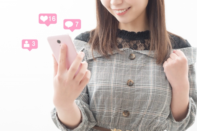 スマホを見て喜ぶ女性